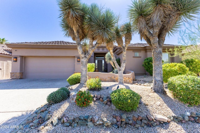 view of front facade featuring driveway, an attached garage, and stucco siding