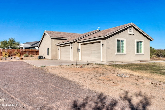 view of side of property featuring a garage and central air condition unit