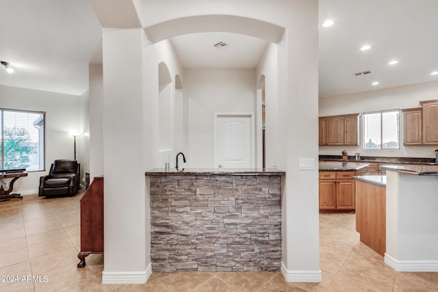 kitchen with dark stone countertops and light tile patterned floors