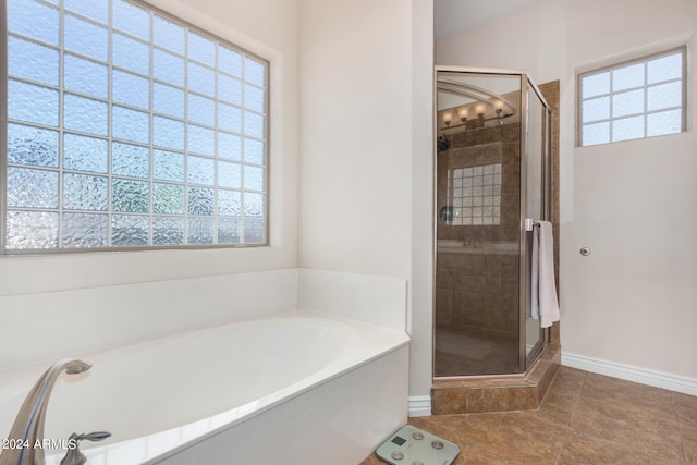 bathroom with a healthy amount of sunlight, separate shower and tub, and tile patterned floors