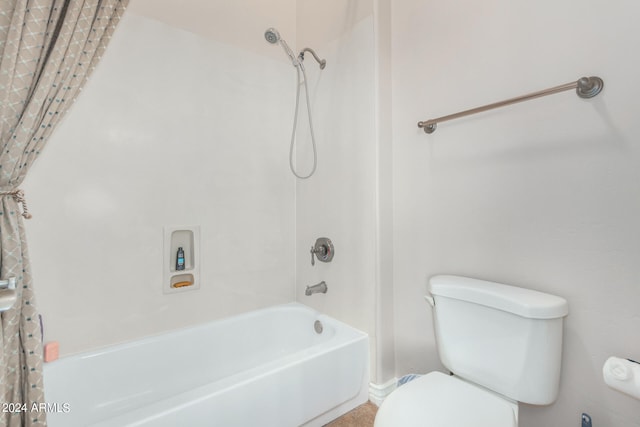 bathroom featuring shower / tub combo and toilet