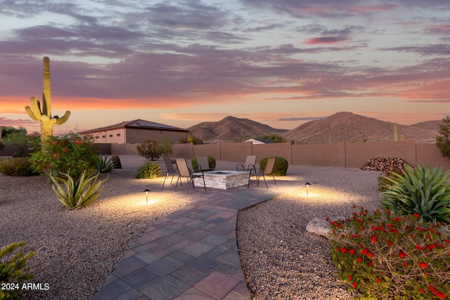 patio terrace at dusk with an outdoor fire pit and a mountain view