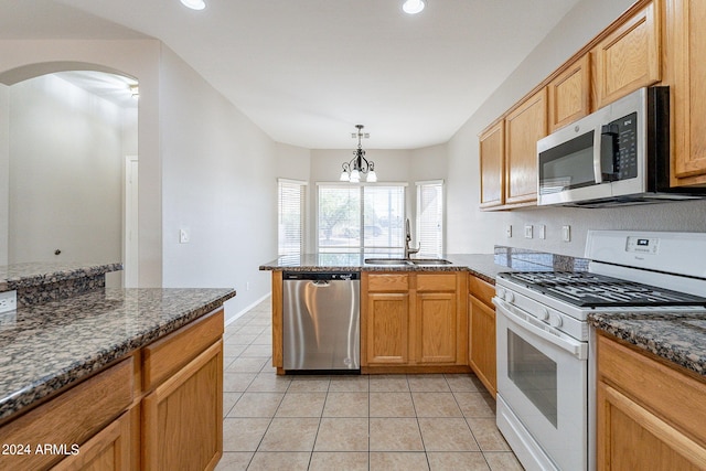 kitchen with a chandelier, sink, hanging light fixtures, appliances with stainless steel finishes, and light tile patterned floors