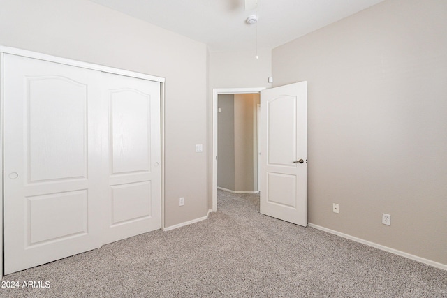 unfurnished bedroom with light carpet and a closet