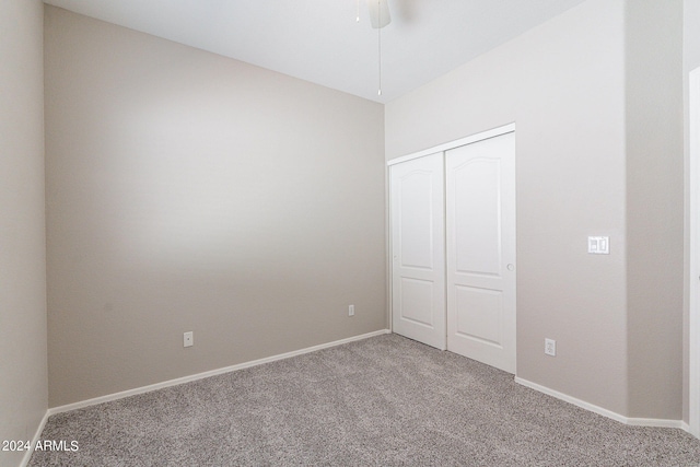 unfurnished bedroom with ceiling fan, a closet, and carpet flooring