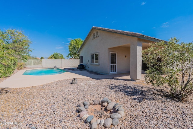 back of house with cooling unit, a fenced in pool, and a patio area