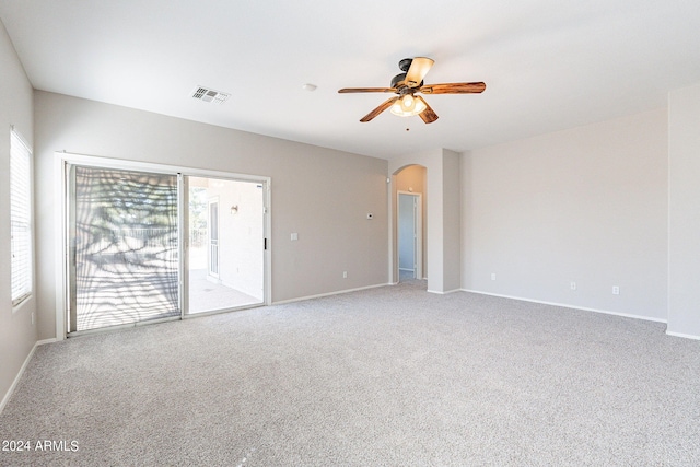 carpeted spare room featuring ceiling fan and plenty of natural light