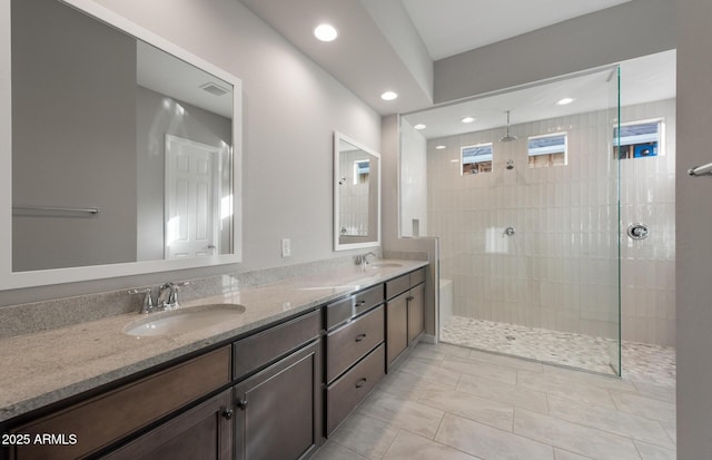 bathroom featuring tile patterned floors, vanity, and a tile shower