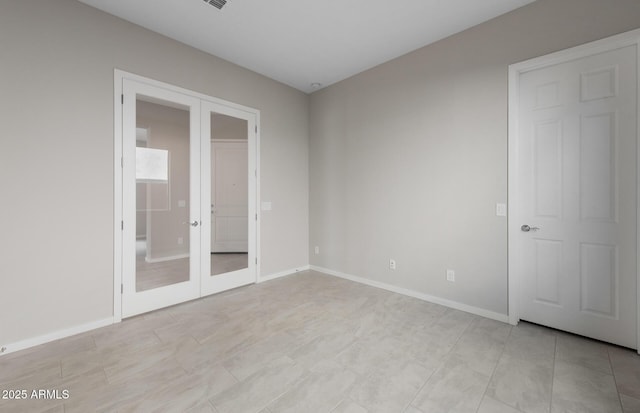 unfurnished room featuring french doors