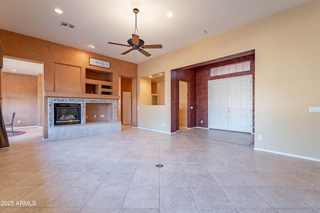 unfurnished living room with light tile patterned floors, a fireplace, and ceiling fan