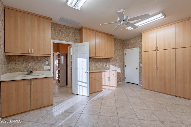 kitchen with sink, light tile patterned floors, ceiling fan, and light brown cabinets