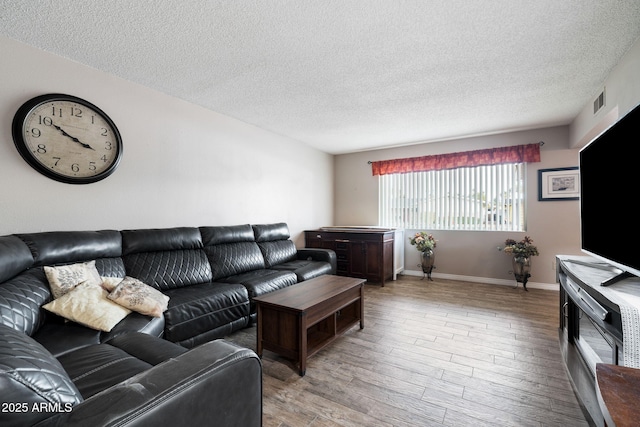 living room featuring a textured ceiling and light wood-type flooring