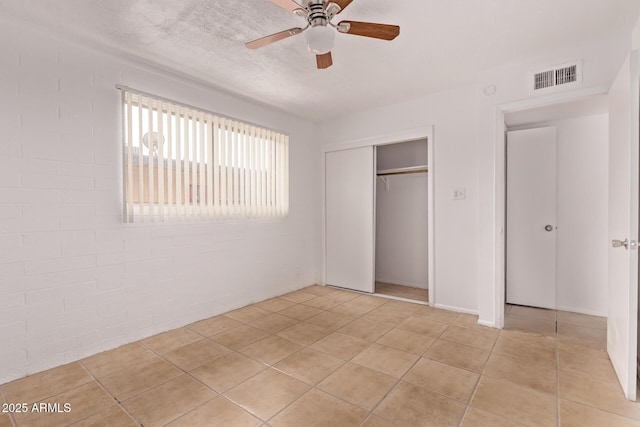 9847 N 11th Ave Unit 2, Phoenix, AZ 85021 - unfurnished bedroom with a closet, light tile patterned floors, a ceiling fan, and a textured ceiling