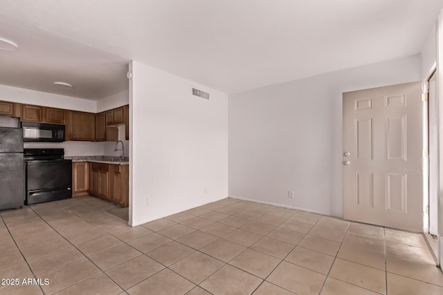 9847 N 11th Ave Unit 2, Phoenix, AZ 85021 - kitchen featuring black appliances, a sink, light countertops, light tile patterned floors, and brown cabinetry