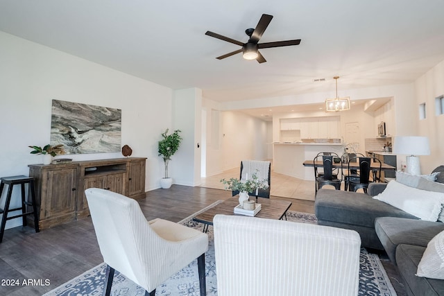 living room featuring dark hardwood / wood-style floors and ceiling fan with notable chandelier