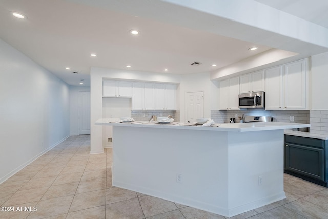 kitchen with white cabinetry, a kitchen island with sink, and electric range