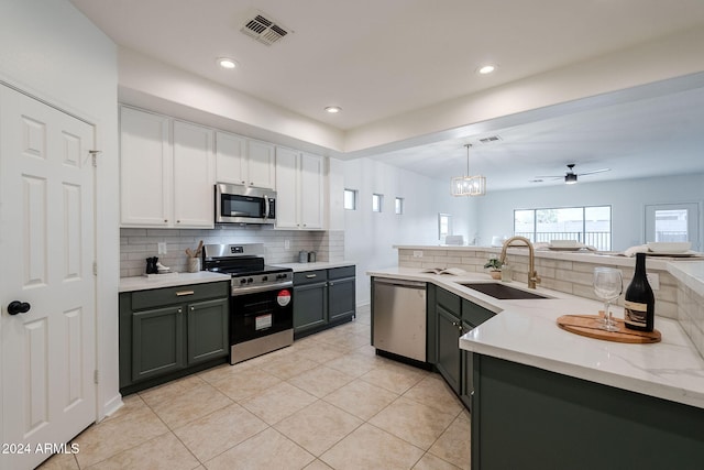 kitchen with appliances with stainless steel finishes, ceiling fan, sink, white cabinetry, and hanging light fixtures