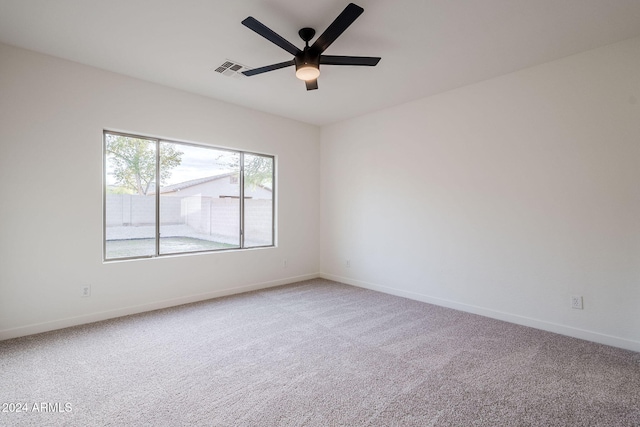 carpeted spare room with ceiling fan