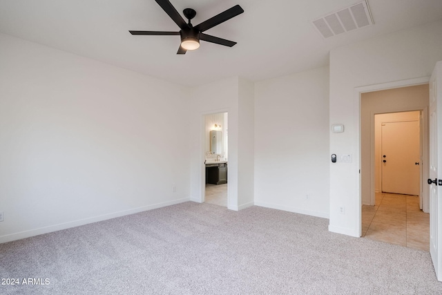 unfurnished bedroom with light carpet, connected bathroom, and ceiling fan