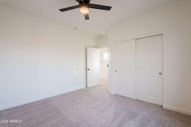 unfurnished bedroom with carpet flooring, a closet, vaulted ceiling, and ceiling fan