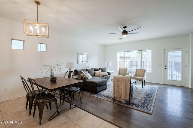 tiled dining space featuring ceiling fan with notable chandelier