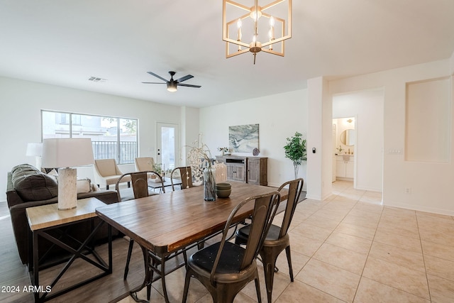 dining room featuring light tile patterned floors and ceiling fan with notable chandelier