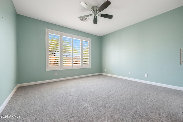 carpeted spare room featuring ceiling fan