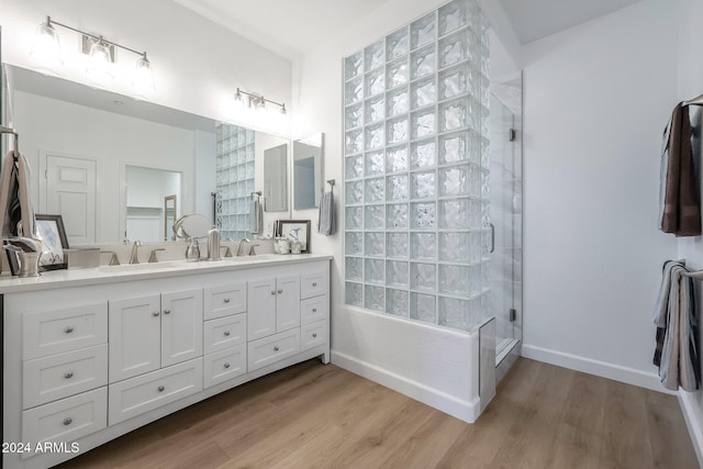 bathroom with hardwood / wood-style floors, double sink vanity, and an enclosed shower