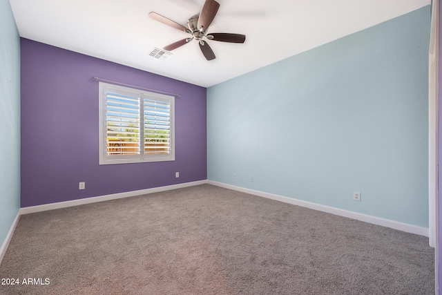 spare room with ceiling fan and carpet