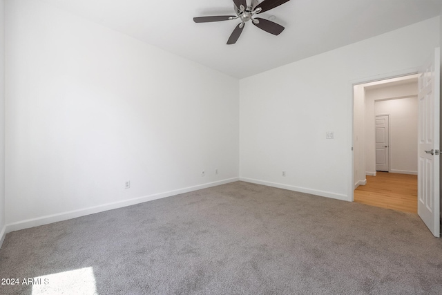 empty room with ceiling fan and light hardwood / wood-style flooring