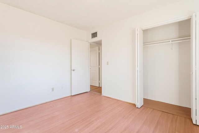 unfurnished bedroom featuring hardwood / wood-style floors and a closet