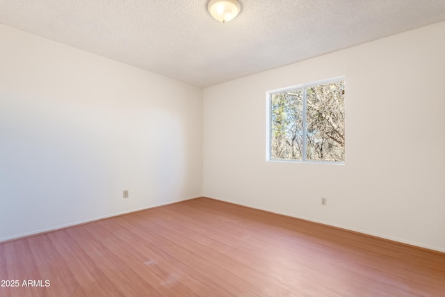 unfurnished room featuring hardwood / wood-style floors and a textured ceiling