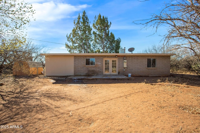 back of property with a storage shed and a patio