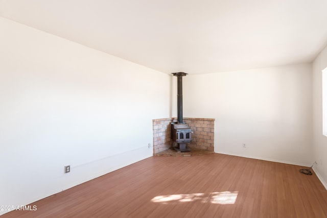 unfurnished living room with a wood stove and hardwood / wood-style floors