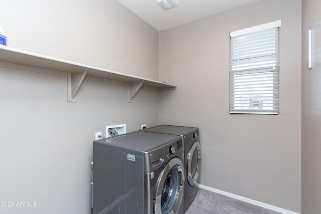 clothes washing area with dark tile patterned floors and washing machine and clothes dryer