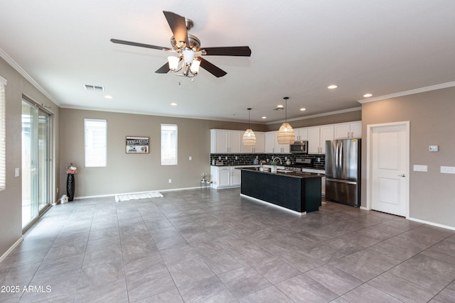 kitchen featuring white cabinetry, stainless steel appliances, a kitchen island, and pendant lighting