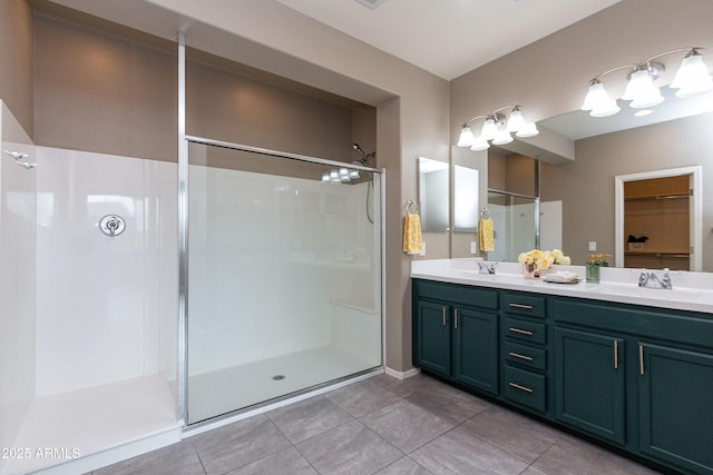 bathroom with a shower with door, vanity, and tile patterned flooring