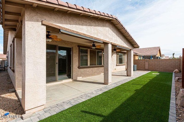 back of house featuring ceiling fan, a yard, and a patio area