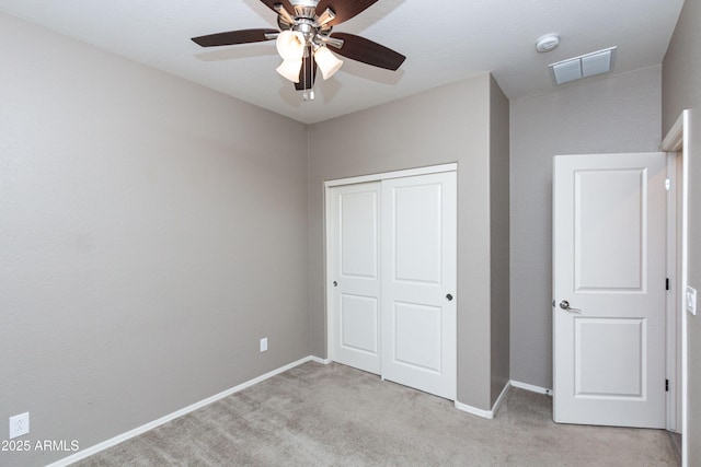 unfurnished bedroom with light carpet, a closet, and ceiling fan