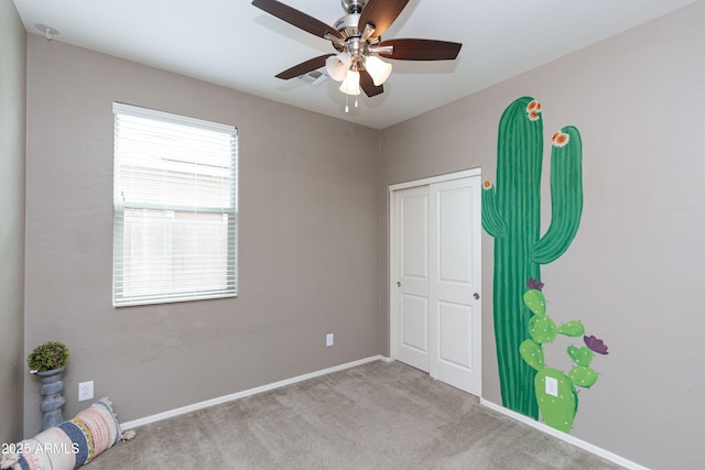unfurnished bedroom featuring ceiling fan, a closet, and light carpet