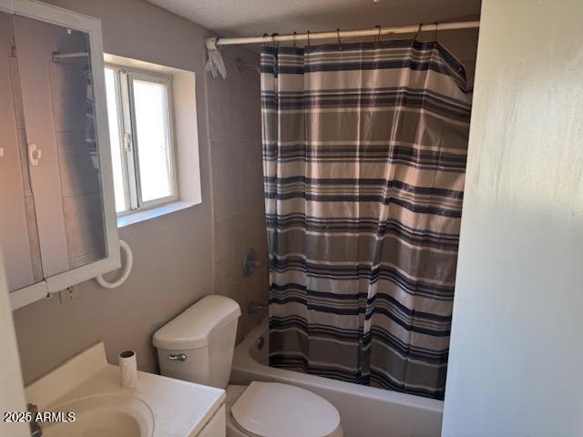 full bathroom with shower / bath combination with curtain, vanity, and toilet