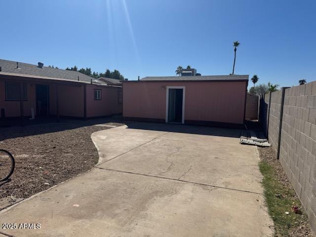 rear view of property featuring a patio area and a fenced backyard