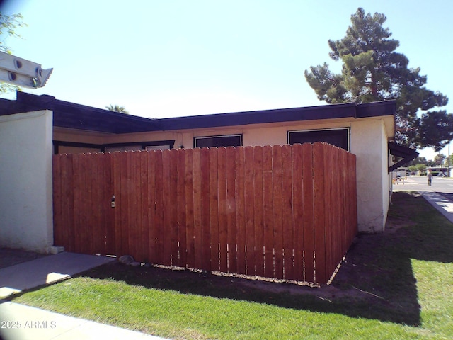 exterior space featuring stucco siding and fence