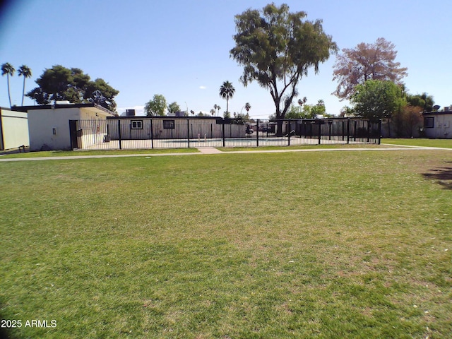 view of home's community featuring a lawn, a swimming pool, and fence