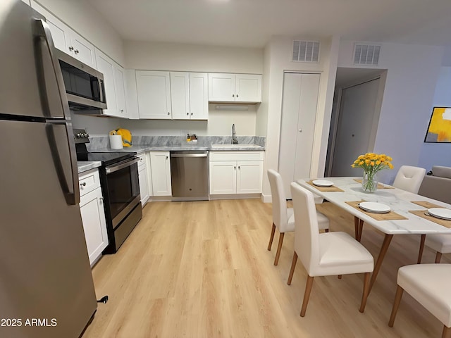 720 S Dobson Rd Unit 95, Mesa, AZ 85202 - kitchen featuring appliances with stainless steel finishes, a sink, light wood-style floors, and white cabinetry