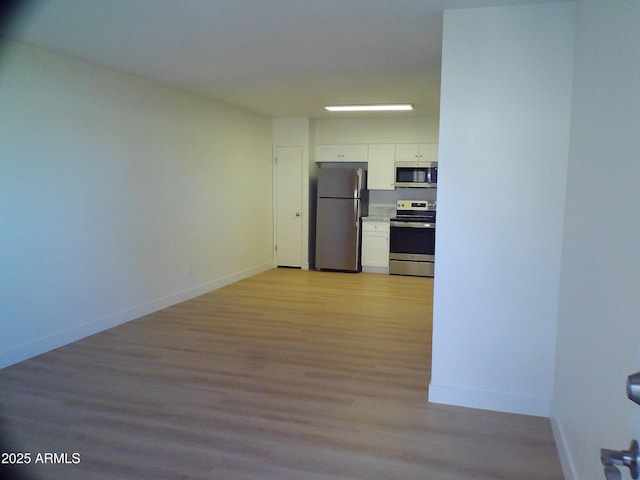 interior space featuring baseboards and light wood-style floors
