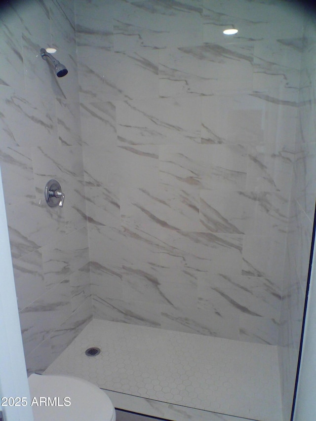 bathroom with toilet and a stall shower