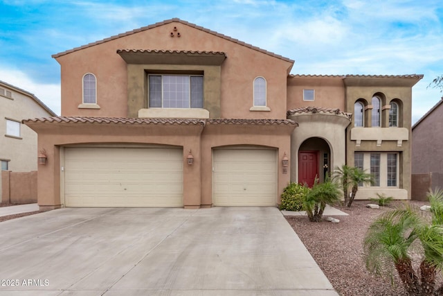 mediterranean / spanish-style house with a tile roof, stucco siding, driveway, and an attached garage