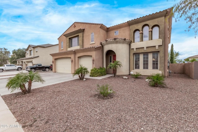 mediterranean / spanish house featuring concrete driveway, fence, a garage, and stucco siding