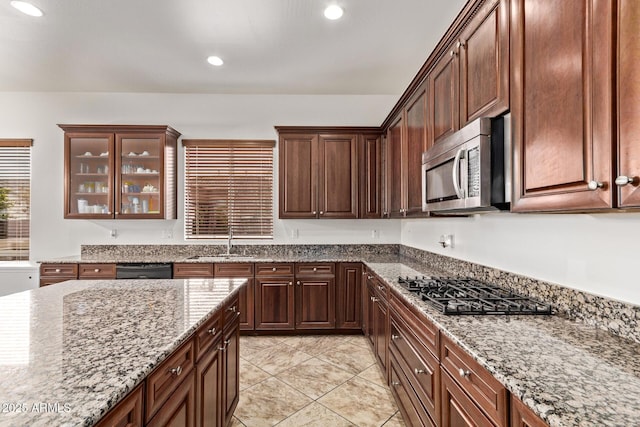 kitchen with gas cooktop, light stone countertops, recessed lighting, a sink, and stainless steel microwave